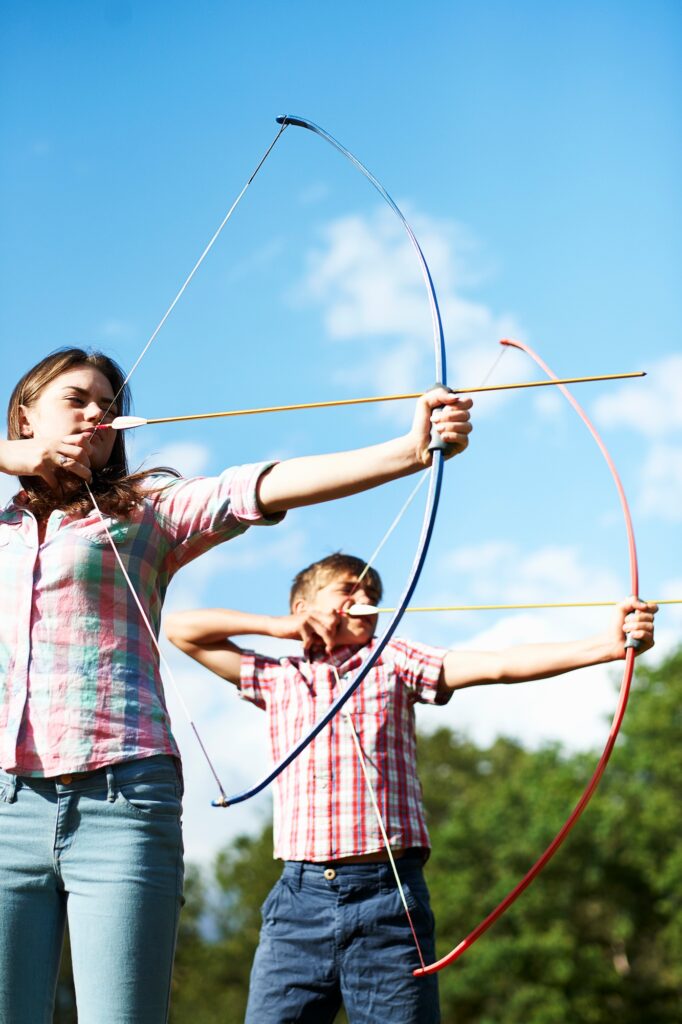 Teenage brother and sister practicing archery